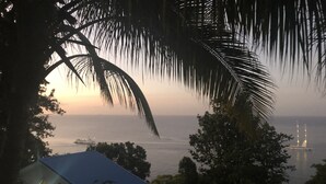 Vista costera con una casa y un barco a lo lejos.