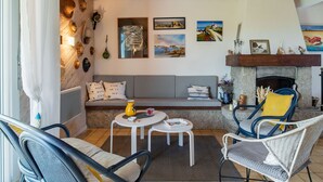 A cozy living room with a stone fireplace, a sofa, and two chairs. - Beautiful private villa for 6 guests with WIFI, TV, terrace and pets allowed (Saint-Égarec)