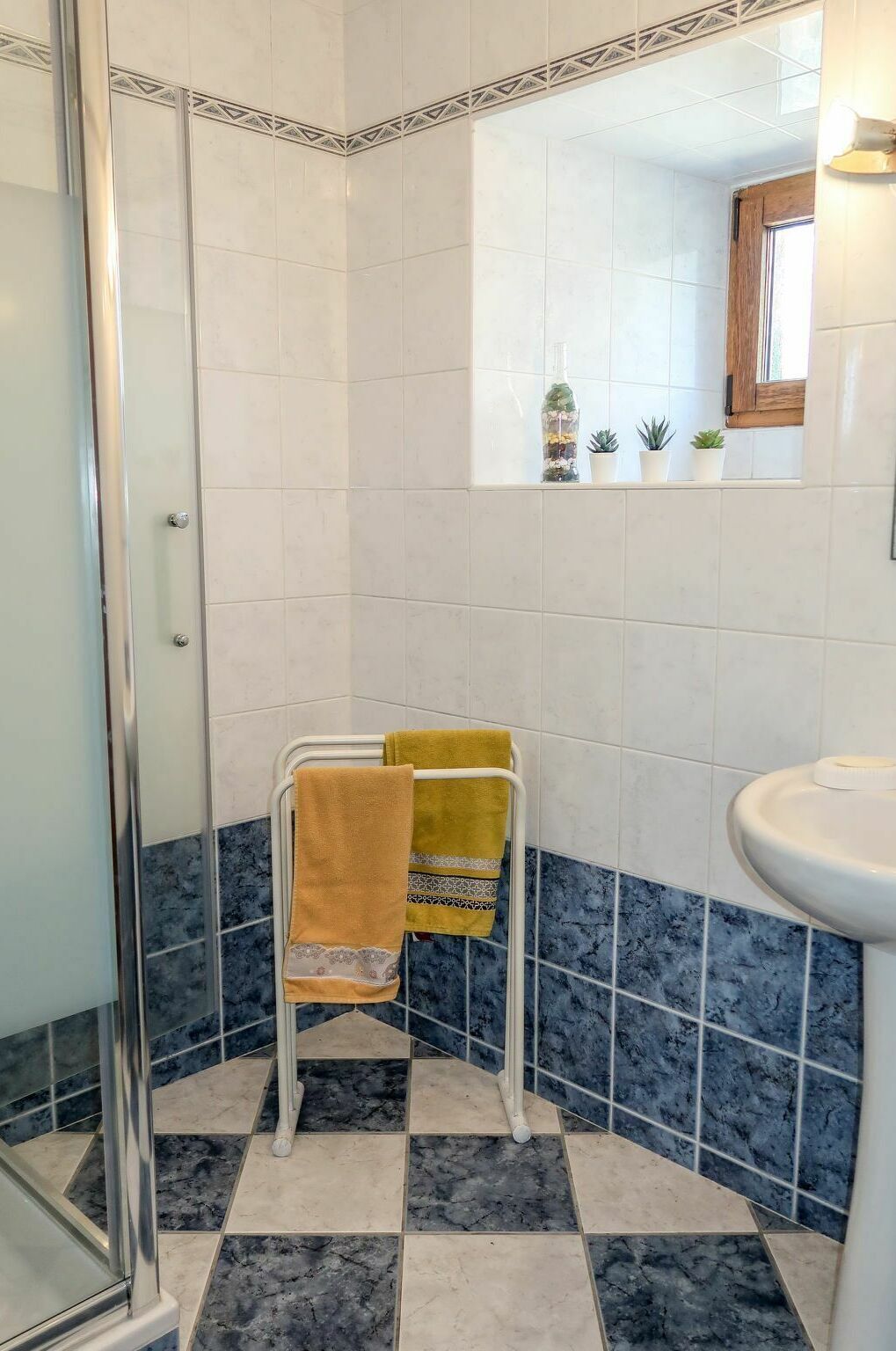 Un baño con cabina de ducha de vidrio, lavabo y espejo.