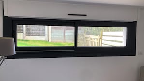 A room with a window overlooking a fenced yard.