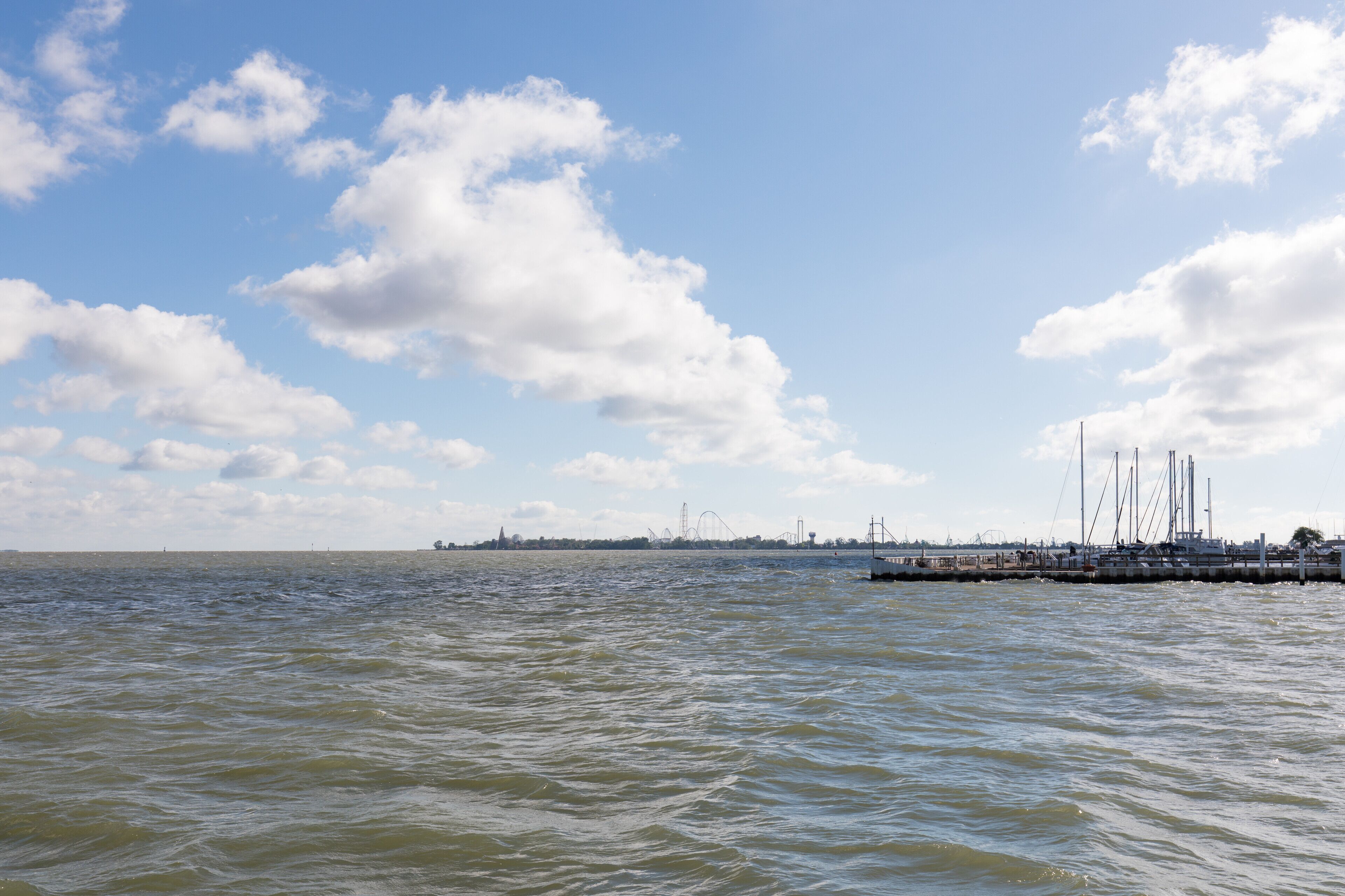A marina with boats docked, a clear sky, and calm water.