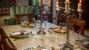 Ein Esszimmer mit gedecktem Tisch, Kerzen und Blick ins Freie.