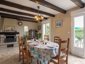 Enjoy meals in this charming dining area with a stone fireplace and large window offering a view of the outdoors.