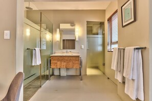 A modern bathroom with a glass shower enclosure, a wooden vanity, and a large mirror. - WINK Foreshore (Cape Town)