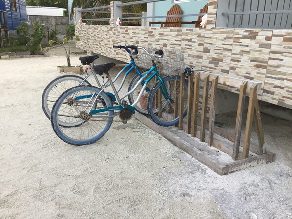 En cykel lænet op ad en mur, med en kurv foran.
