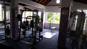A gym with weightlifting equipment, a bench, and a window with a view of greenery. - Chill on tha hill/ free wi fi <br>A/c, free wi fi, gated community  (ocho rios)