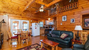 A log cabin interior with a dining area, kitchen, and living room. - Climber`s Haven- Hot Tub, Firepit, Sunroom, WiFi, 5 mins to Natural Bridge (Rogers)