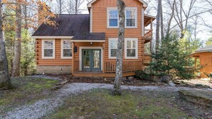 A log cabin with a front porch, a deck, and a chimney. - Climber`s Haven- Hot Tub, Firepit, Sunroom, WiFi, 5 mins to Natural Bridge (Rogers)