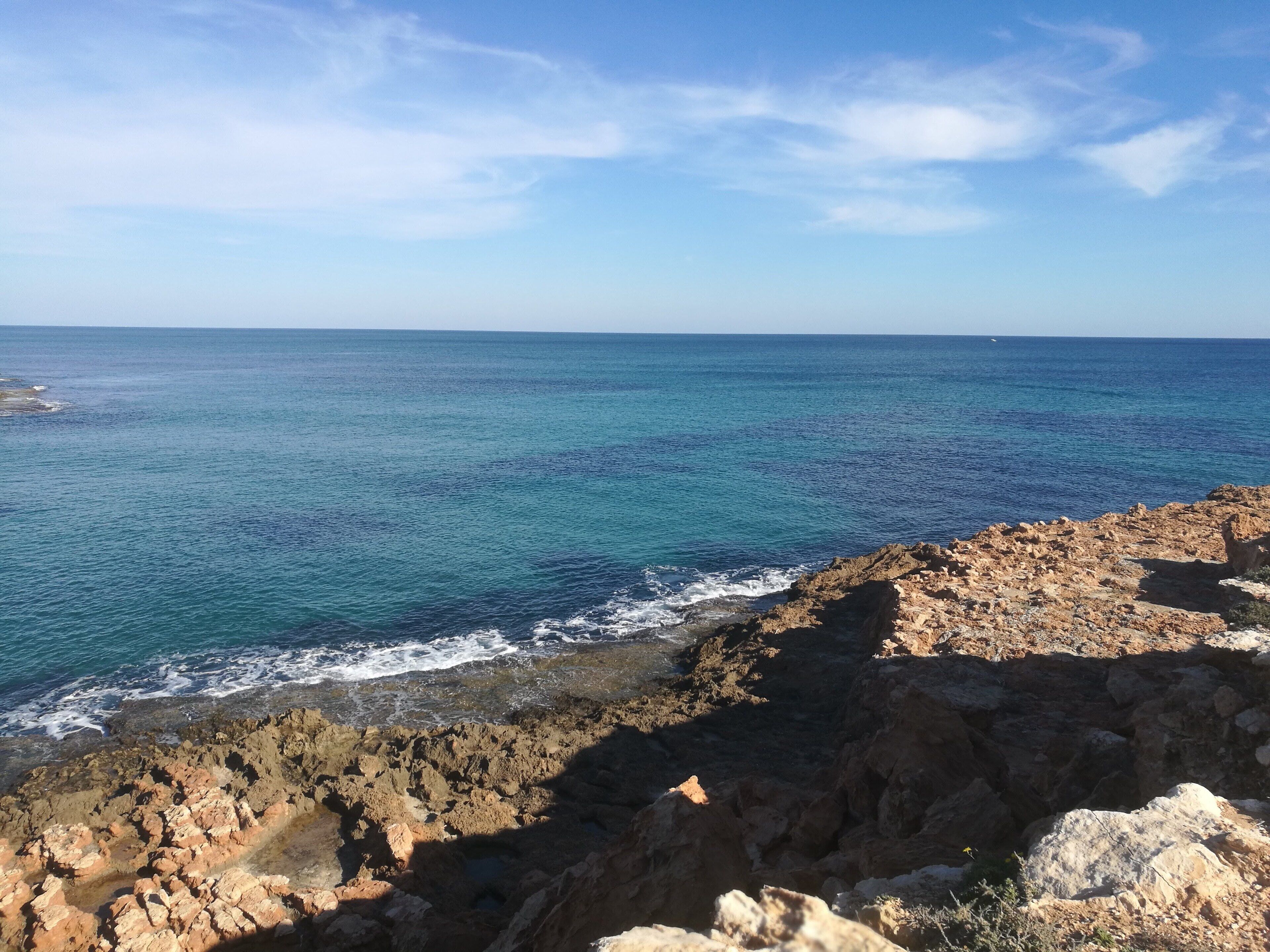 Un paysage côtier caractérisé par un terrain rocheux et une vue sur la mer.