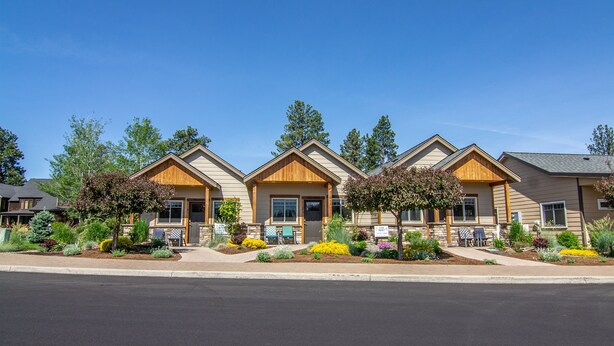 A row of three-story buildings with a uniform architectural style, featuring wooden front facades and large windows. - Views! 1Blk to Town, Clean+Charming,pets ok-Middle (Sisters)