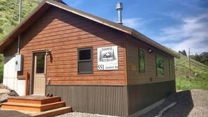 A wooden cabin with a sign reading "Jardine Retreat 551 Jardine Rd."