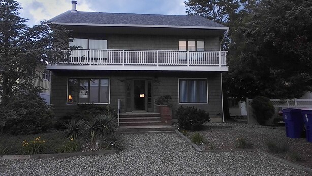 A two-story house with a balcony, a front door, and a small porch. - --------------------------------- (Toms River)