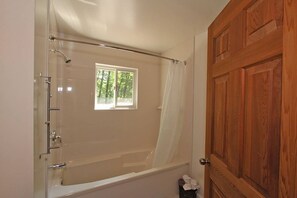 Bathtub, hair dryer, towels, toilet paper