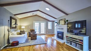 A spacious living room with hardwood flooring, a fireplace, a television, and a cozy seating area. - Oakway Blissful Abode, Walk to Autzen Stadium (Eugene)