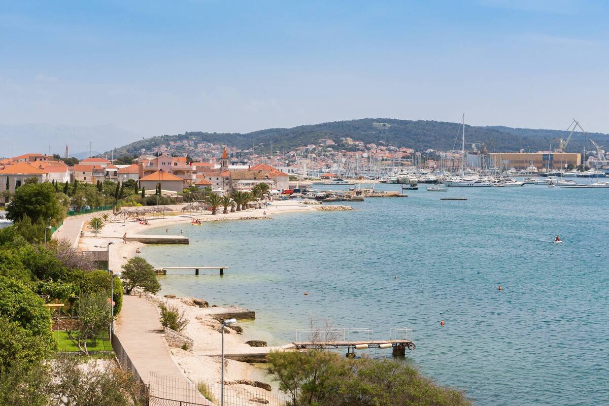 A coastal town with a marina, sandy beach, and residential buildings.