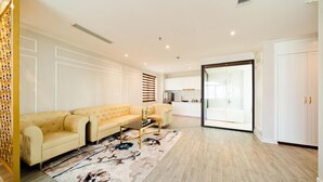 A spacious living room with a beige sofa, a coffee table, and a patterned rug.