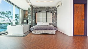 Ein modernes Schlafzimmer mit einem großen Bett, einer eingebauten Badewanne und Blick ins Freie.