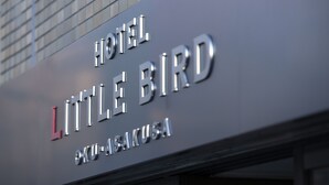A hotel sign with the name "HOTEL LITTLE BIRD" and the location "KU-AISAKUYA".
