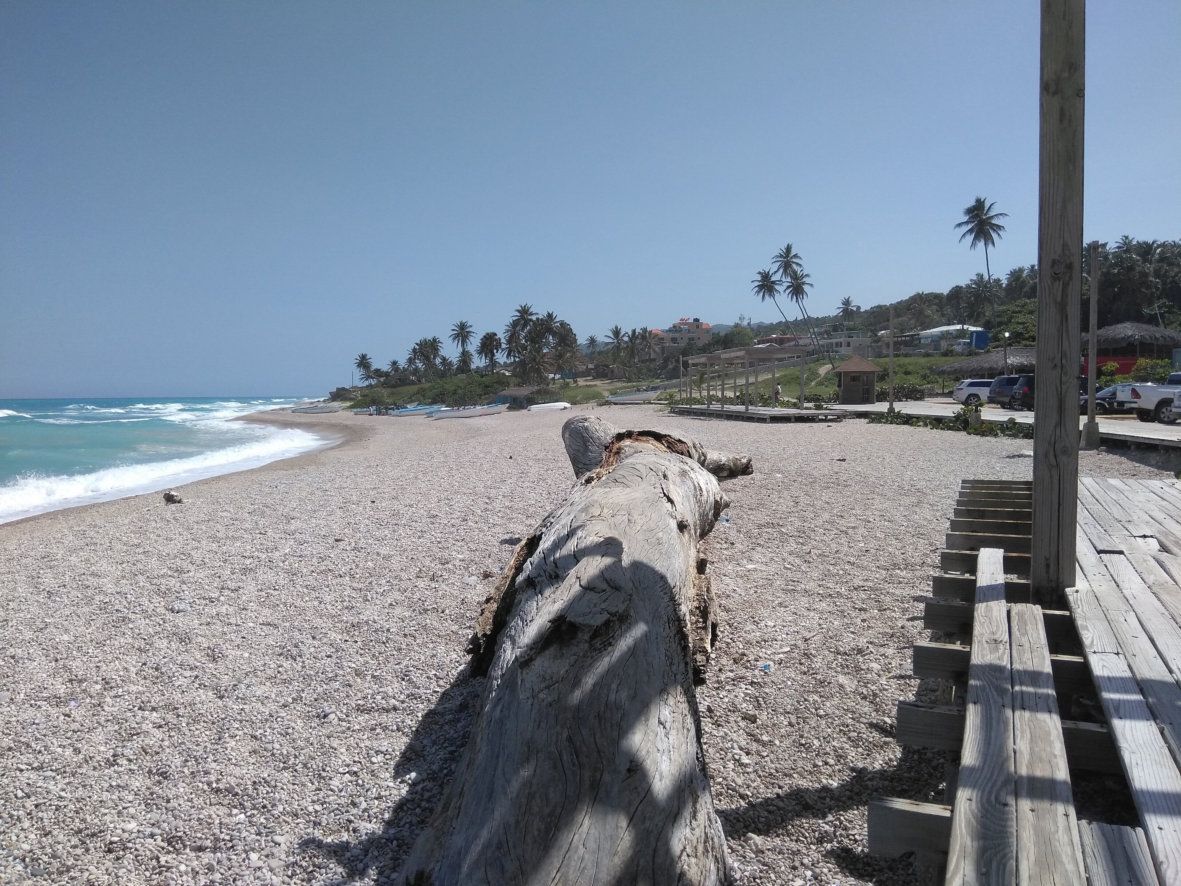 Une plage avec une promenade en bois et une vue sur l’océan.