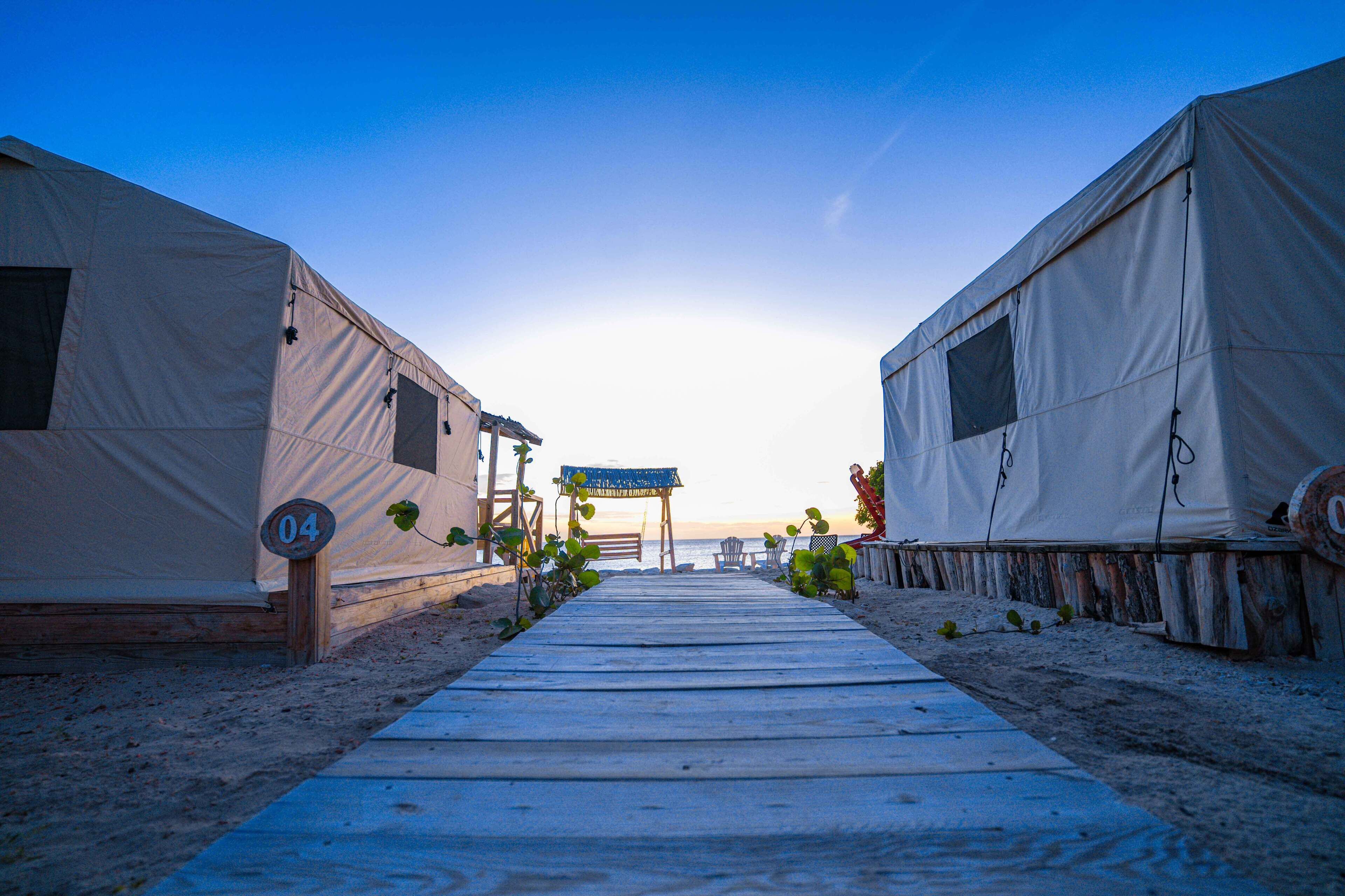 Un sentier menant à des cabanes de plage avec vue sur la mer.