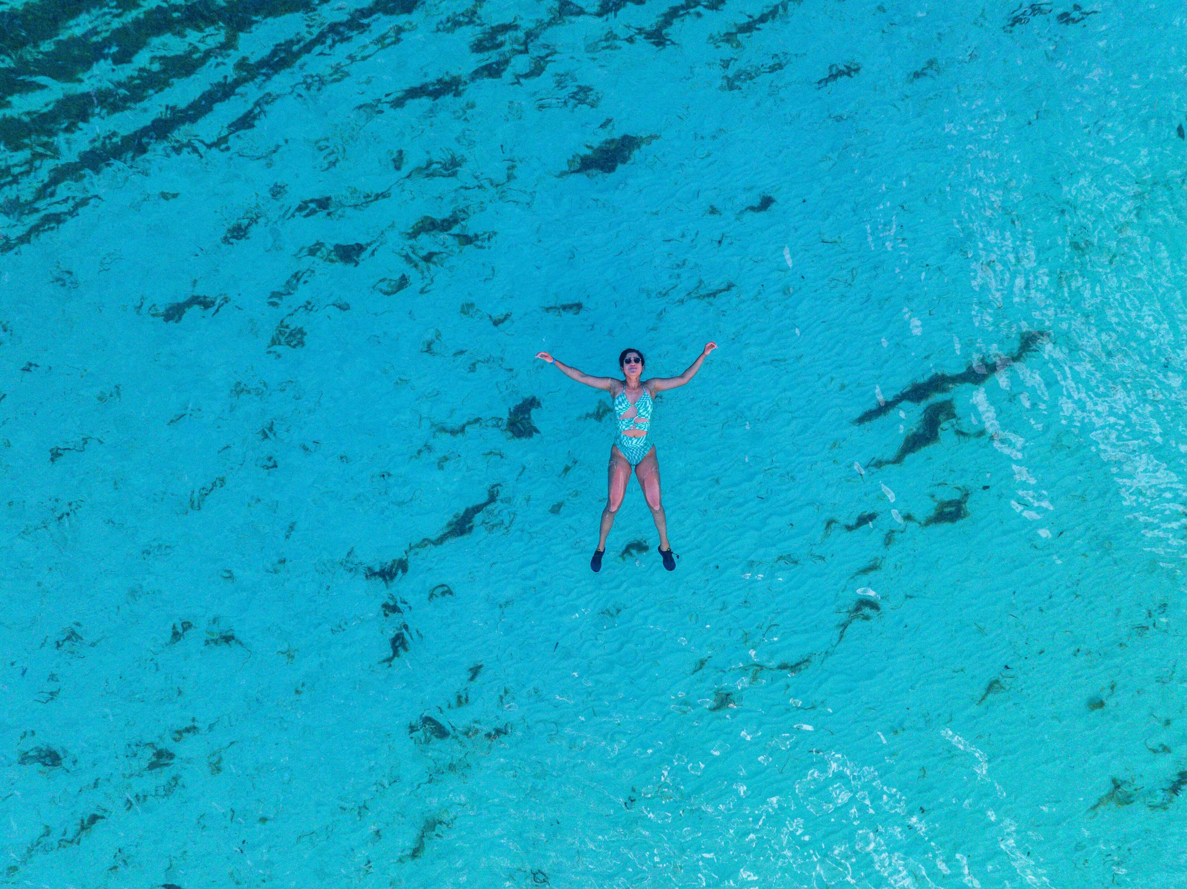 A person floating in clear blue water.