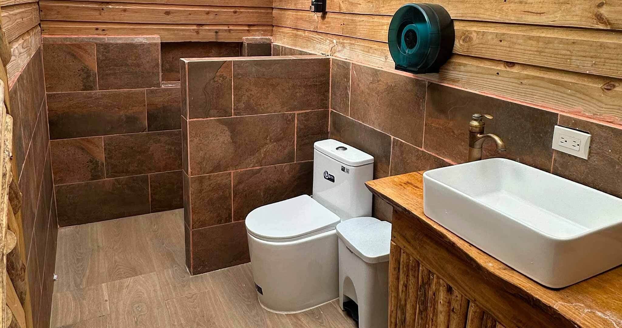 A bathroom with a shower, toilet, and sink.