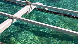 Vista nítida de la estructura de madera de un barco y el mar turquesa.