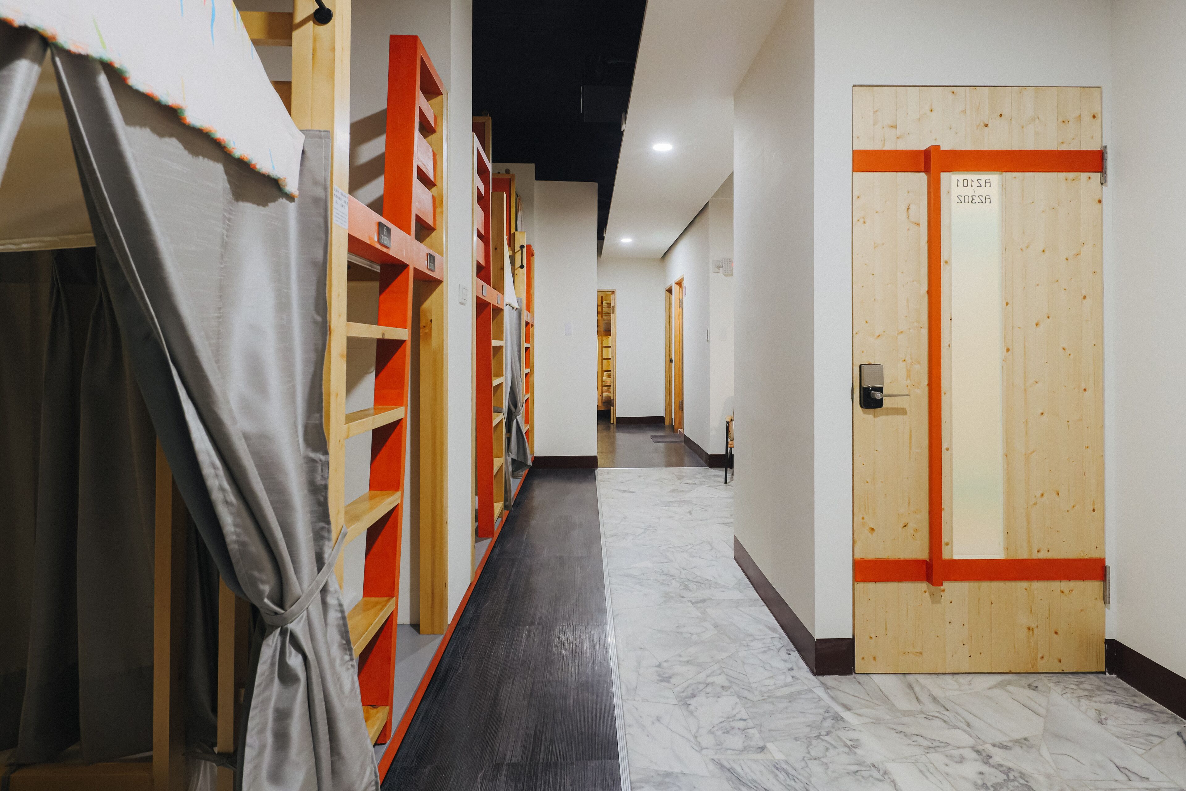 A hallway with wooden shelving units, a door with a sign, and a marble floor.