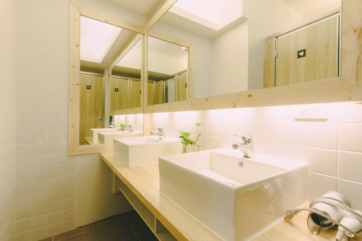 Ein modernes Badezimmer mit zwei Waschbecken, einem großen Spiegel und einer Duschkabine.