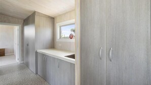 A modern kitchen with grey cabinetry, a window with a view, and a countertop. - Surfs up beach Bach  (Colac Bay)
