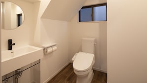 A small, modern bathroom with a white sink, a toilet, and a mirror. - Hotel Little Bird Oku-asakusa (Tokyo)