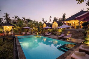 Alberca al aire libre y camastros 