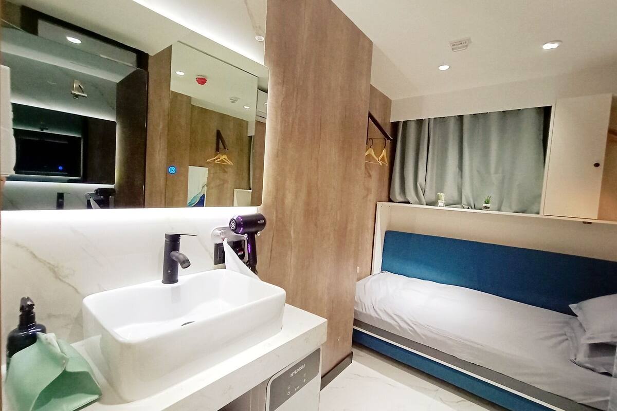 A modern bathroom with a large sink, mirror, and a shower area.