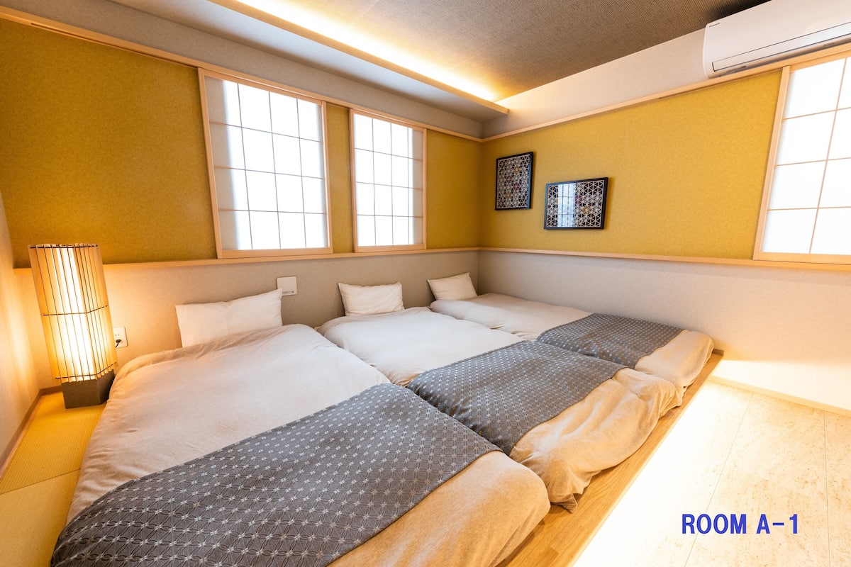A hotel room with two beds, a bedside lamp, and a window with a view.