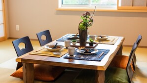 Una mesa de comedor dispuesta con platos, tazones y un florero con flores.