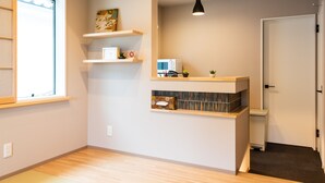 Una cocina moderna con estantes de madera, microondas y una lámpara colgante.