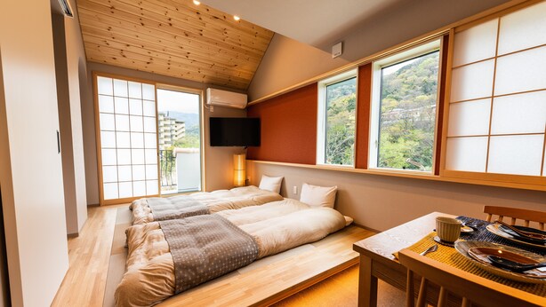 Una habitación con dos camas, una mesa de comedor y un televisor.