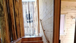 A wooden staircase leading to a bedroom with a bed and a window. - Minnow cabins, peaceful bush setting, cabin 2 (Lower Beulah)