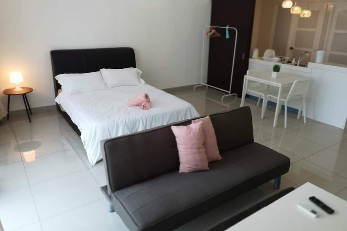 Une chambre d’hôtel moderne équipée d’un lit, d’un canapé, d’un bureau et d’une chaise.