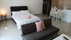 Una habitación de hotel moderna con cama, sofá, escritorio y silla.