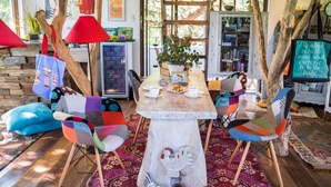 A cozy reading nook with a wooden table, colorful chairs, and a bookshelf filled with books. - La Bella Tagaytay Residences (Tagaytay)