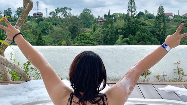 A person relaxing in a hot tub with arms raised, overlooking a body of water and greenery. - La Bella Tagaytay Residences (Tagaytay)