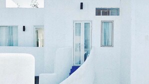 A modern white building with a curved staircase, large windows, and a blue outdoor area. - La Bella Tagaytay Residences (Tagaytay)