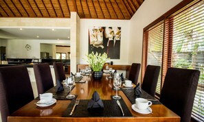 Enjoy a formal dining experience with a long table set for a meal, surrounded by comfortable chairs and elegant decor.