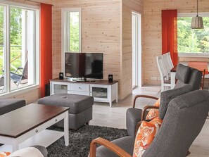 A modern living room with a television, sofa, and dining area.
