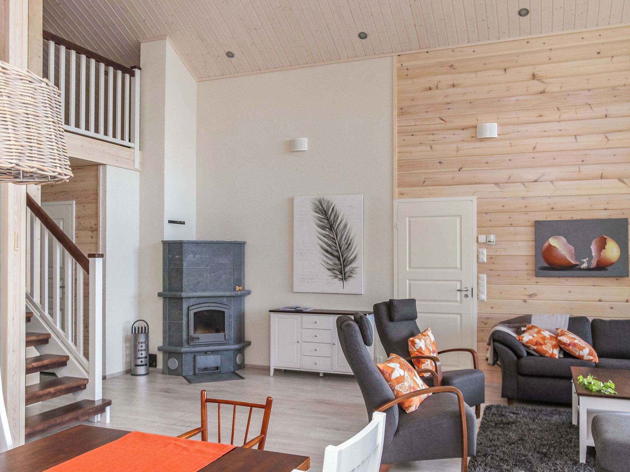 Un salon moderne avec une cheminée, un coin repas et un escalier.