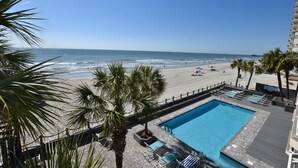 Ein Poolbereich mit Blick auf Strand und Meer.