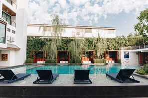 Een buitenzwembad en ligstoelen