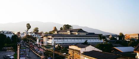 A street view with buildings, a sign indicating a WiFi rate, and a mountain in the background.
