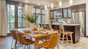 Una cocina moderna con una isla central, una mesa de comedor de madera y sillas.